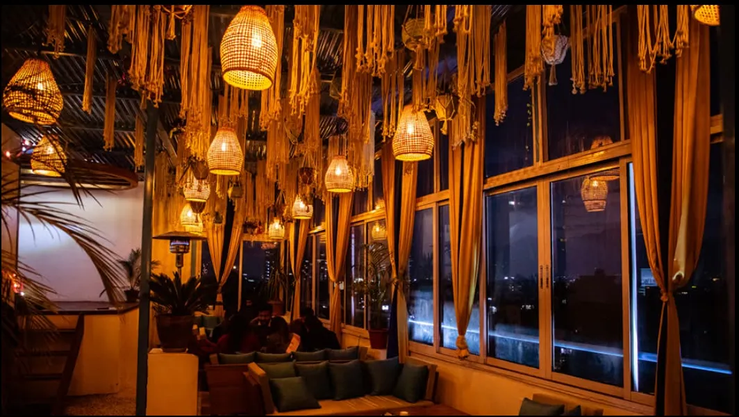 Warm woven rattan lanterns glowing over the indoor lounge at night